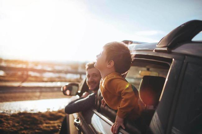 Child smiling out of car window